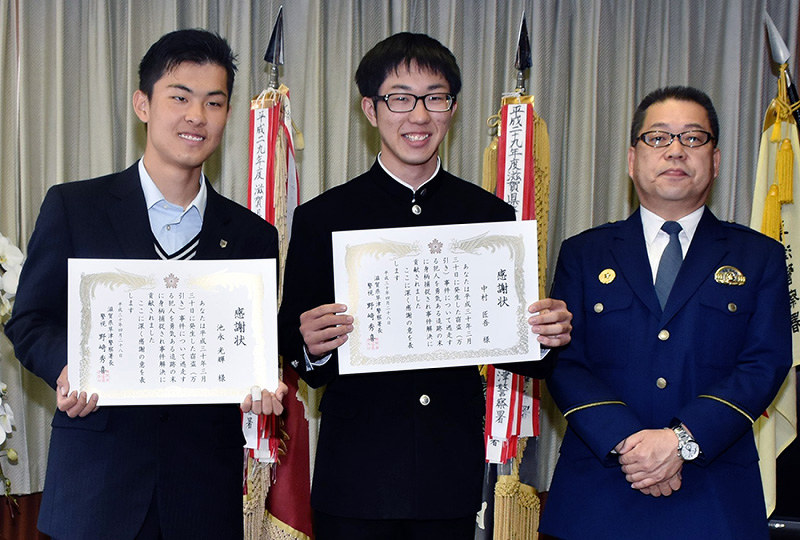 野崎秀喜・草津署長(右端)から感謝状を贈られた池永光輝さん(左端)と中村匠吾さん=滋賀県草津市の同署で、諸隈美紗稀撮影