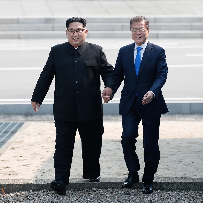 手を取り合って軍事境界線を越える北朝鮮の金正恩朝鮮労働党委員長(左)韓国の文在寅大統領=韓国・板門店で4月27日、韓国共同写真記者団