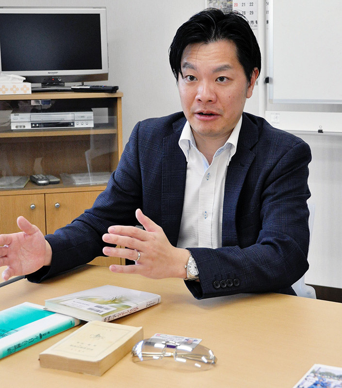 事故当時、身につけていたサングラスや持っていた大学の教科書を前に事故を振り返る横山健太さん=兵庫県尼崎市内で、山本愛撮影