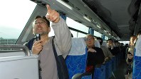 ツアーのバスで一番前の席に座り解説を行う藻谷浩介さん