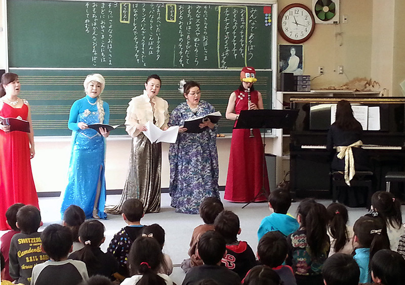 楽器を届けた宮城県内の小学校で演奏と歌を披露する宝塚演奏家連盟のメンバー(2015年2月)=同連盟提供