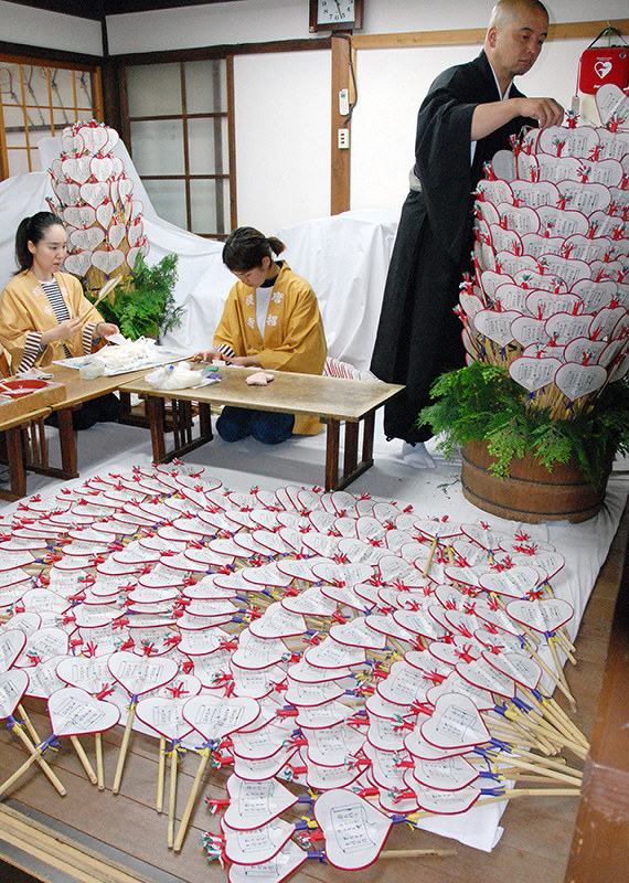 うちわまきに向けて宝扇づくりをする僧侶と寺職員=奈良市の唐招提寺で、大川泰弘撮影