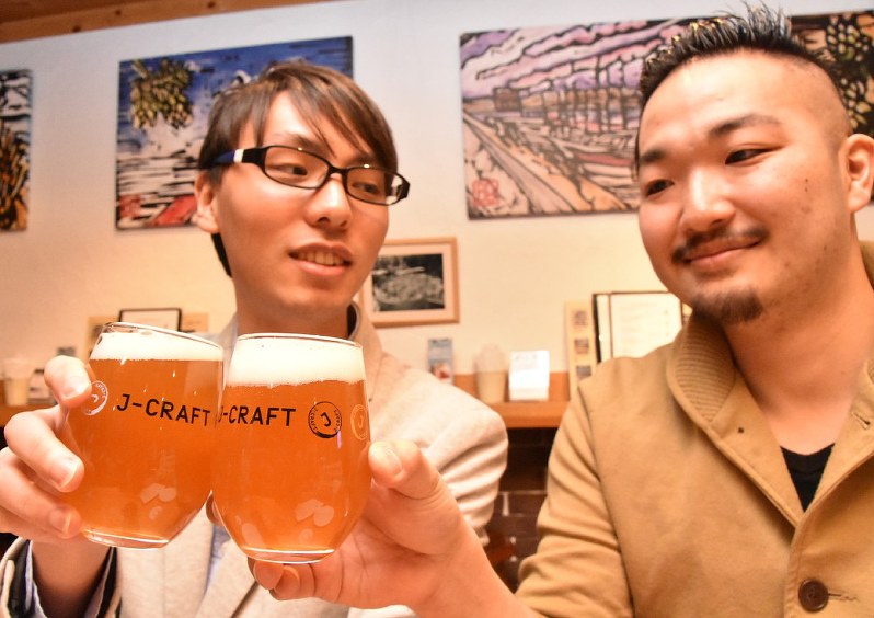 クラフトビールで乾杯する男性客=東京都目黒区の中目黒タップルームで