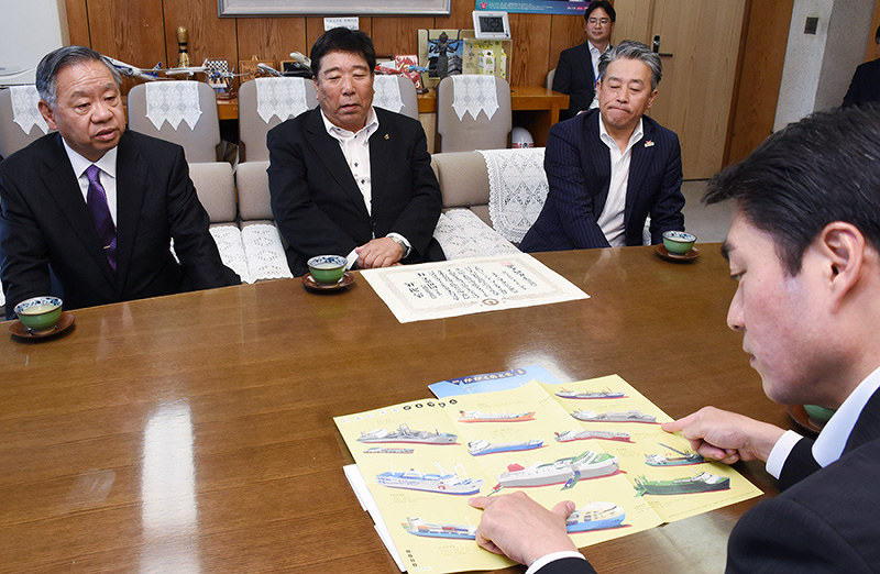 絵本を見ながら懇談する高知県海運組合のの岡田俊夫理事長(左奥から2人目)や尾崎正直知事(右手前)ら=高知県庁で、郡悠介撮影
