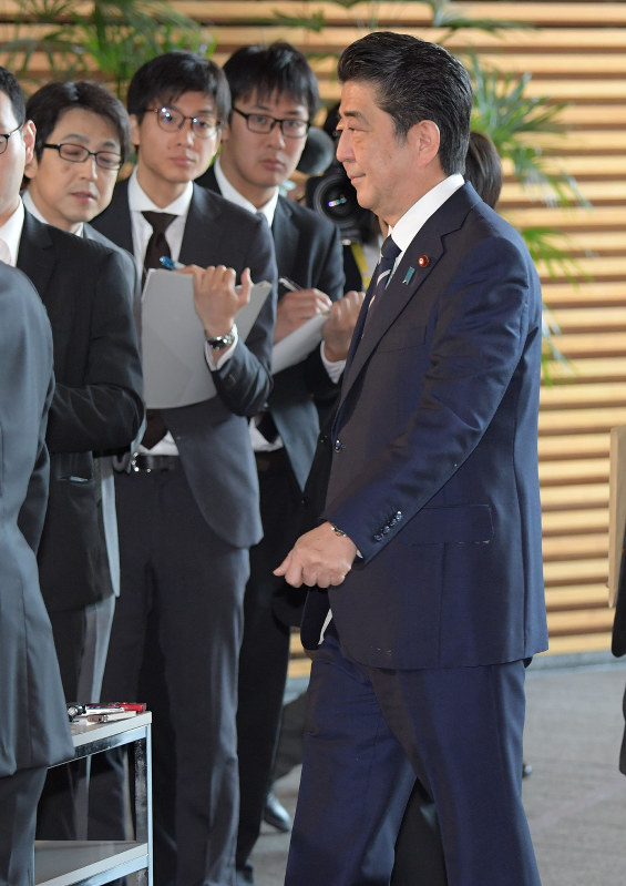 学校法人「加計学園」による獣医学部新設を巡る愛媛県の新たな文書について質問するため待ち構えている記者団に歩み寄る安倍晋三首相(右)=首相官邸で2018年5月22日午前8時20分、川田雅浩撮影