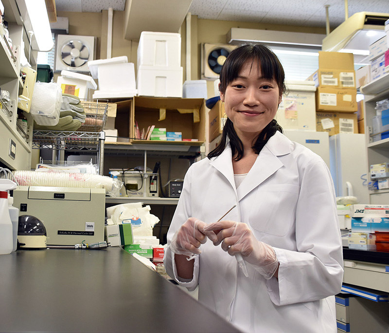 綿棒を手にする高知大の橋田裕美子助教=高知県南国市の同大で、松原由佳撮影