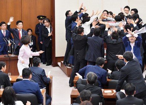 衆院厚生労働委員会で働き方改革関連法案の採決があり、高鳥修一同委員長（右奥）の席に抗議のため詰め寄る野党議員たち。奥左から２人目は挙手する加藤勝信厚労相＝国会内で２０１８年５月２５日午後５時５３分、宮間俊樹撮影