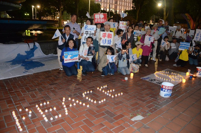 統一旗の前で朝鮮半島の平和を訴える人々=名古屋市中区で2018年5月26日午後8時23分、駒木智一撮影