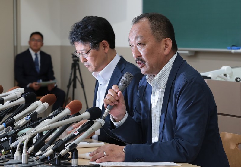 記者会見をする関学大アメフット部の鳥内秀晃監督(右)と小野宏ディレクター。奥は被害選手の父・奥野康俊さん=兵庫県西宮市で2018年5月26日午後3時31分、小出洋平撮影