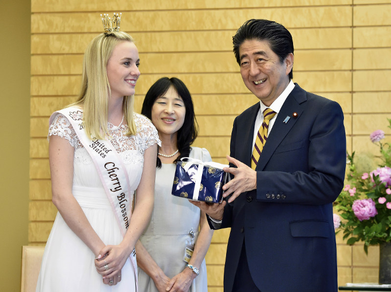 全米さくらの女王のマーガレット・オメーラさん(左)から記念品を受け取り、笑顔を見せる安倍晋三首相(右)=首相官邸で2018年5月29日午後3時18分、渡部直樹撮影