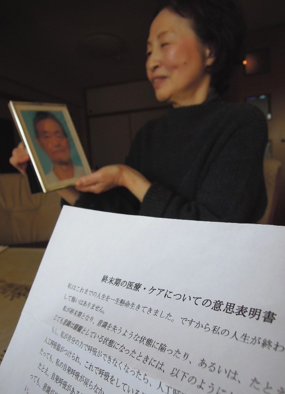 意思表明書(写真手前)を残した五十嵐靖夫さんの遺影を眺める妻みさ代さん=千葉県松戸市で