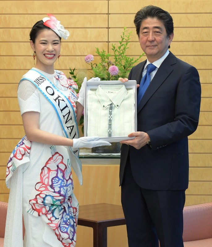ミス沖縄(左)からかりゆしを贈られる安倍晋三首相=首相官邸で2018年5月31日午前9時39分、川田雅浩撮影