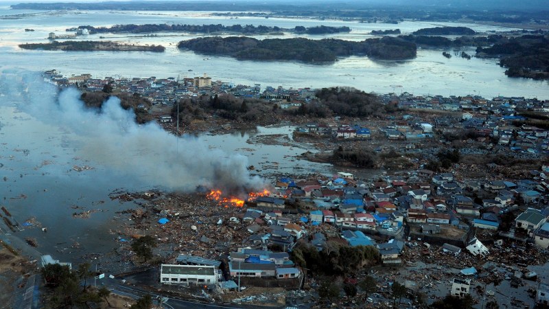 東日本大震災で、海岸線一帯が津波で水没し、火災が発生した住宅=福島県相馬市で2011年3月11日午後5時25分、本社機から貝塚太一撮影