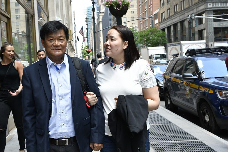 結核で失明し、父親(左)の介添えを受けながら街を歩くマリア・テングさん=米ニューヨーク・マンハッタンで、國枝すみれ撮影
