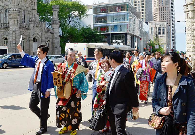ちんどん屋とマグニフィセントマイルを練り歩く吉村洋文・大阪市長(左)=米シカゴ市で、真野敏幸撮影