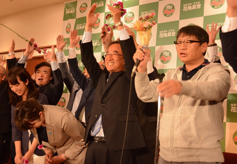当選確実の報を受けて万歳をする花角氏(中央)=新潟市中央区で2018年6月10日午後10時38分、堀祐馬撮影