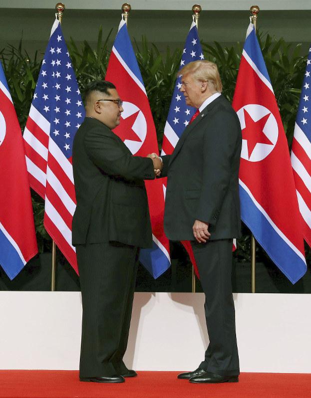 握手するトランプ米大統領(右)と北朝鮮の金正恩朝鮮労働党委員長=シンガポール・カペラホテルで12日、ロイター