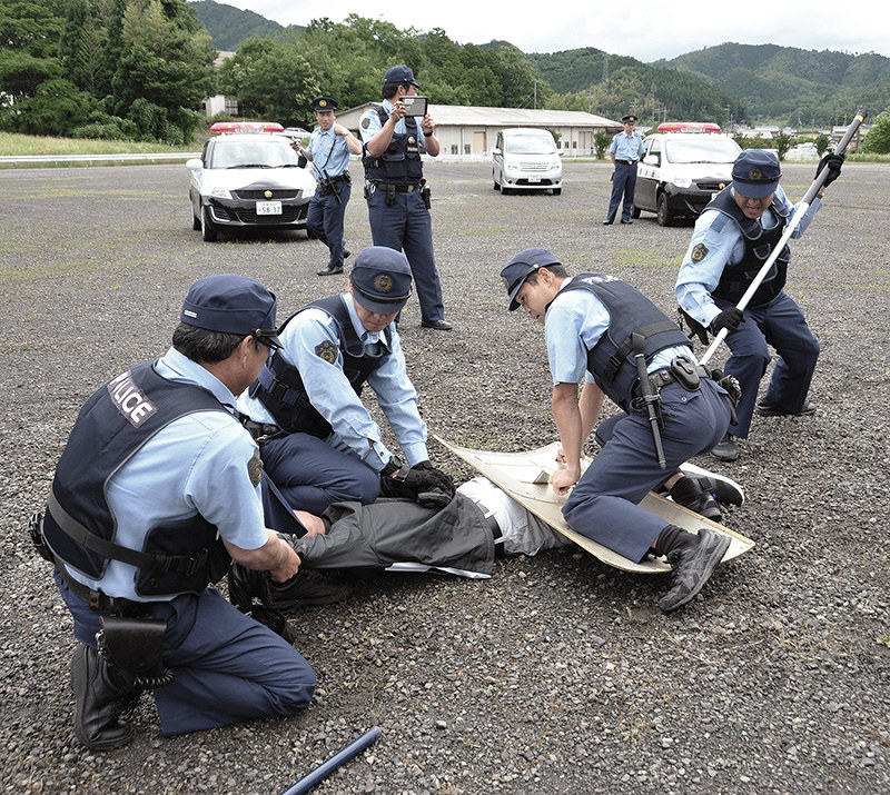 訓練で密入国者役を複数で取り押さえる警察官=京都府綾部市上杉町で、佐藤孝治撮影
