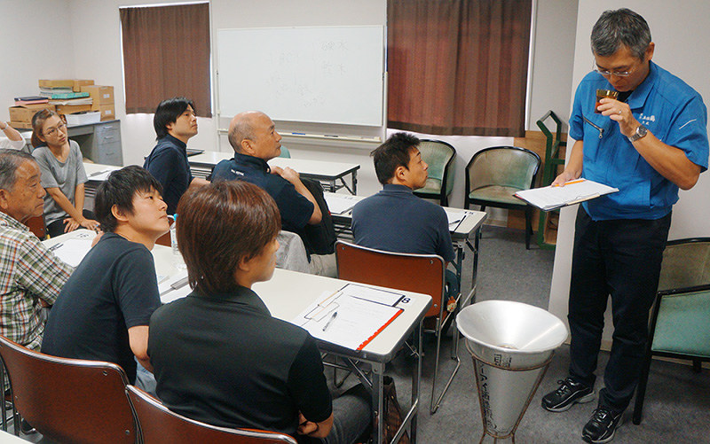 講師が実演するきき酒の方法に耳を傾ける受講者=高知市廿代町の県酒造組合で、植田憲尚撮影