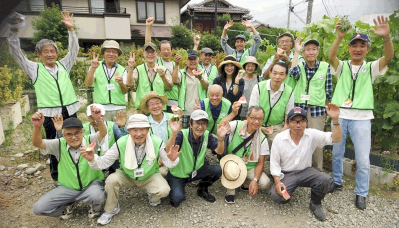 市民農園「豊中あぐり」で収穫したスイカを食べる人たち=2017年夏(豊中市社会福祉協議会提供)