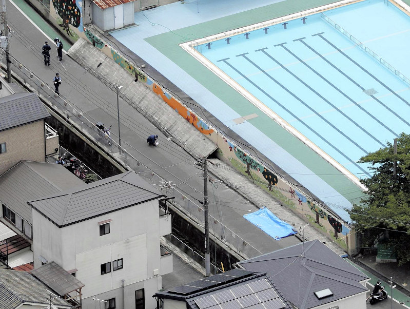 倒れた壁に女児が下敷きになった現場=大阪府高槻市の市立寿栄小で2018年6月18日午前9時58分、本社ヘリから三村政司撮影