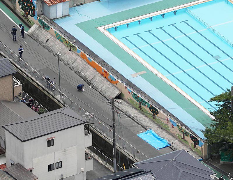 倒れた壁に女児が下敷きになった現場=大阪府高槻市の市立寿栄小で2018年6月18日午前9時58分、本社ヘリから三村政司撮影