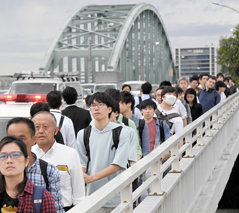 新淀川大橋を徒歩で渡って帰宅する人たち=大阪市で2018年6月18日午後6時半、山崎一輝撮影
