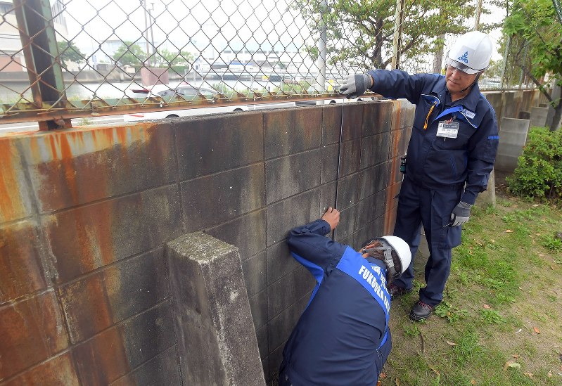 中学校内のブロック塀を調べる福岡市教委の職員=福岡市博多区で2018年6月19日、津村豊和撮影