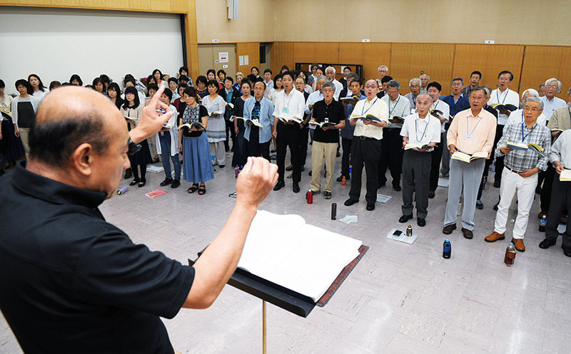 指揮に合わせ熱心に練習する神戸フロイデ合唱団の団員ら=神戸市灘区深田町4の六甲道勤労市民センターで、峰本浩二撮影