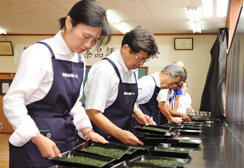 福知山、舞鶴、綾部3市で生産された新茶の品質を厳正に評価する審査員ら=京都府綾部市宮代町のJA京都にのくに茶業センターで、佐藤孝治撮影