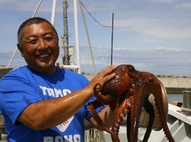 「日本代表には活躍してほしい」とミズダコを手にする漁師の阿部喜三男さん=北海道小平町臼谷の漁港で2018年6月29日、渡部宏人撮影