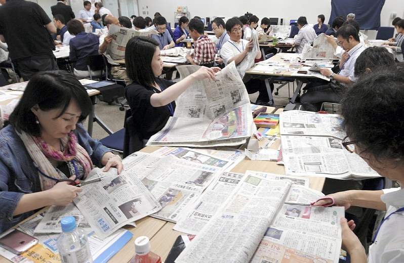 全国各地の新聞から興味ある記事を切り抜く参加者たち=ニュースパークで6月24日