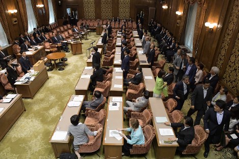 参院政治倫理・選挙制度特別委員会で公職選挙法改正案の自民党案の採決があり、抗議のため退席する立憲、維新の議員たち（手前右）の奥で起立する自民、公明の議員たち＝国会内で２０１８年７月１１日午後０時５５分、川田雅浩撮影