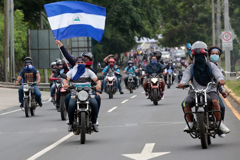 車やバイクに乗ってオルテガ政権に対し抗議の声を上げる人々=首都マナグア近郊で15日、ロイター