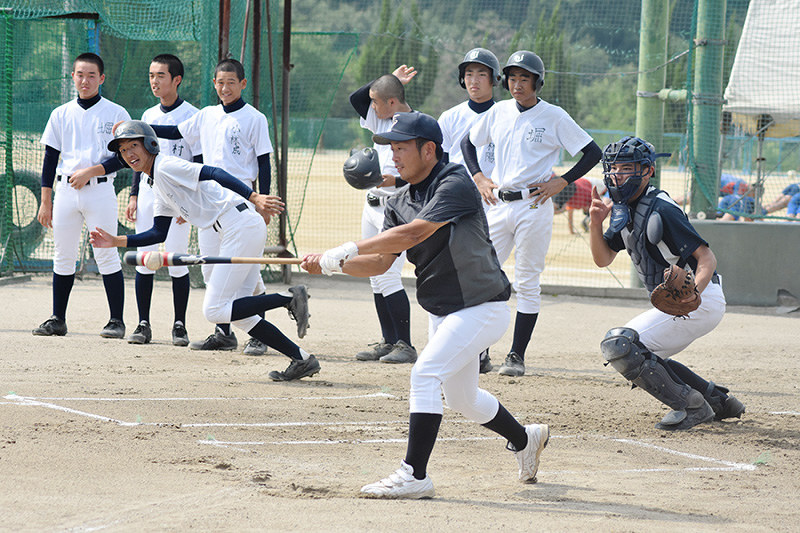 総合技術高の赤松智樹監督(手前)のノックに合わせて一塁へ走る如水館の選手(左から2人目)=広島県三原市の如水館高で2018年7月17日、安田光高撮影
