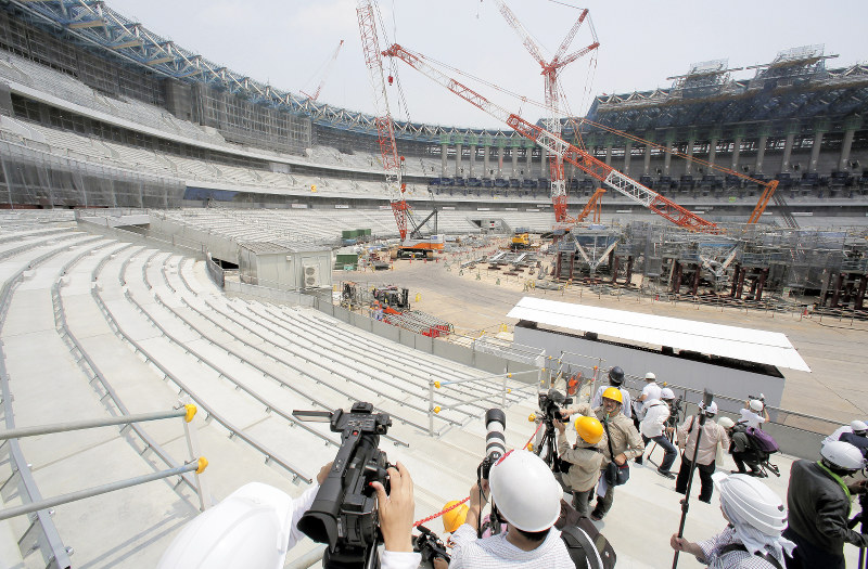 報道陣に公開された建設中の新国立競技場。国産木材を使った屋根(右上)も一部組み立てが始まっている=東京都新宿区で2018年7月18日、和田大典撮影