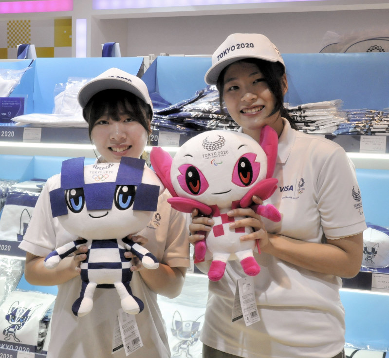 東京五輪マスコット「ミライトワ」(左)とパラリンピックマスコットの「ソメイティ」のぬいぐるみを手に笑顔をみせるマスコットハウスのスタッフ=東京都千代田区の東京ミッドタウン日比谷で2018年7月22日午後1時13分、倉沢仁志撮影