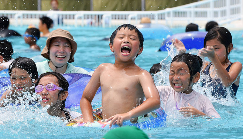 西日本豪雨による土砂災害の被害に遭った「グリーンピアせとうちサンシャインプール」が営業を開始し、元気いっぱいに遊ぶ子どもたち=広島県呉市で2018年7月21日午後0時50分、猪飼健史撮影