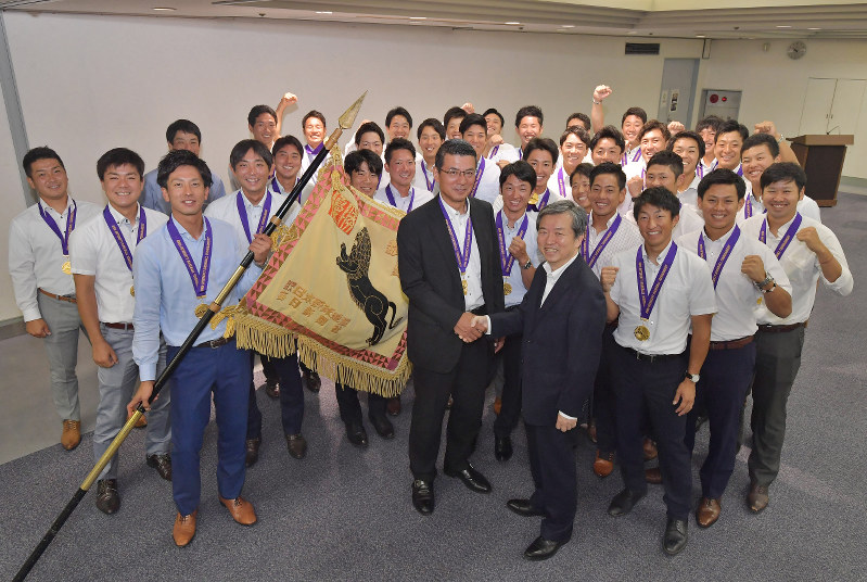 優勝から一夜明けて選手たちと毎日新聞社を訪問し、丸山昌宏社長(中央右)と握手をする大阪市・大阪ガスの橋口博一監督(中央)=東京都千代田区で2018年7月25日午前10時15分、西本勝撮影