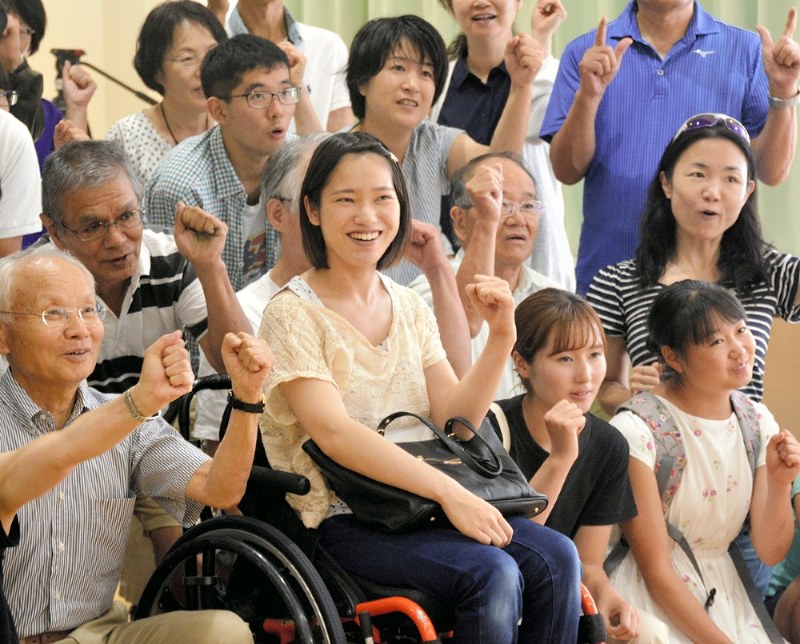 2020年に都市ボランティアとして活動する仲間たちと集まる尾高さん(中央)=千葉市美浜区で