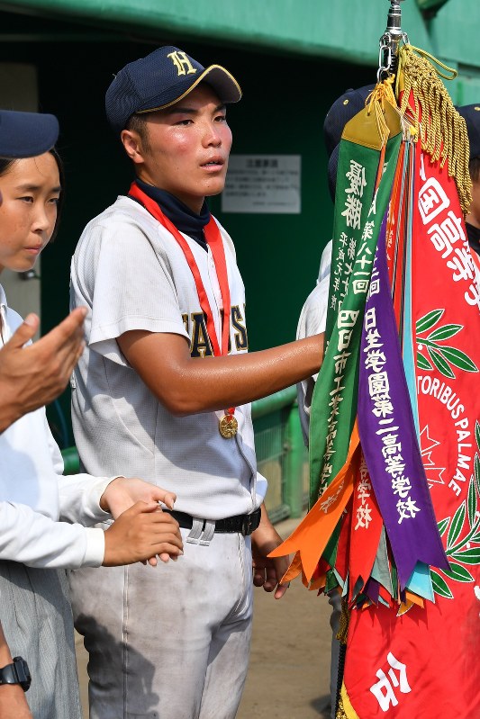 三重大会の優勝旗を持つ白山の辻宏樹主将=三重県四日市市の市営霞ケ浦球場で2018年7月25日、大西岳彦撮影
