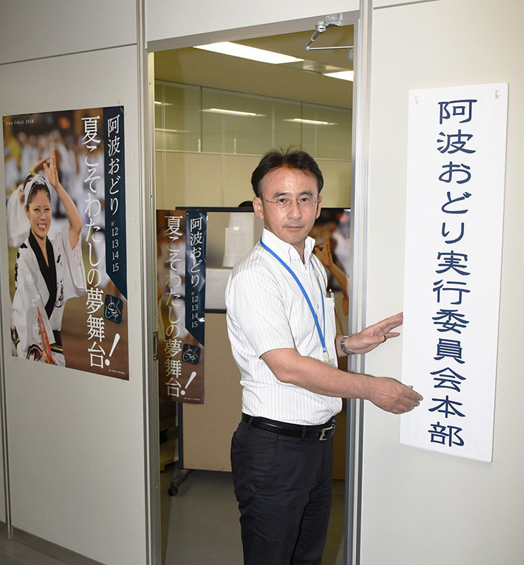 阿波おどり実行委員会本部の入り口に看板を掛ける須藤浩三理事=徳島市役所で、大坂和也撮影