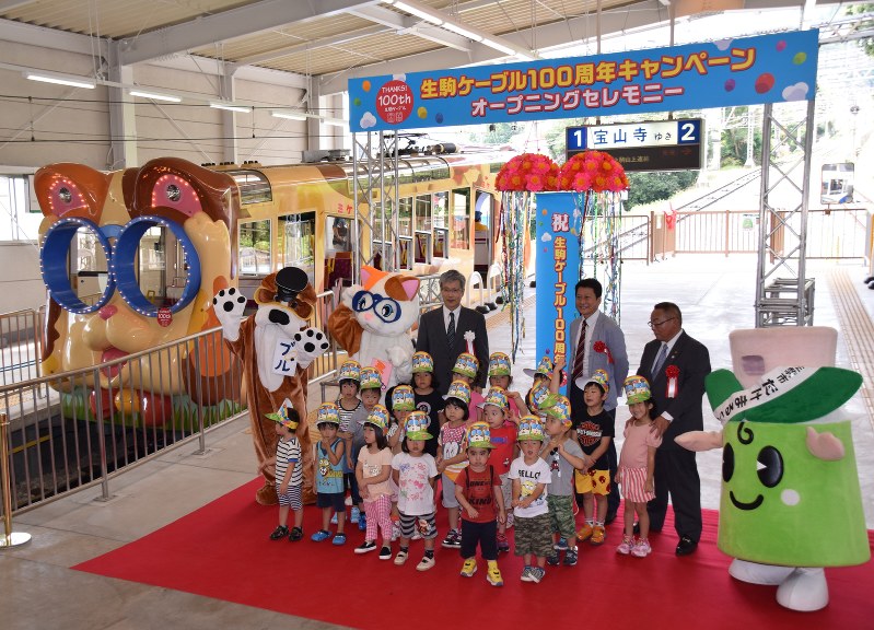 くす玉開披などで生駒ケーブルの営業開始100周年を祝ったセレモニー=奈良県生駒市の鳥居前駅で、熊谷仁志撮影