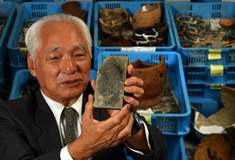 ７２年ぶりに見つかったすずり（縦約１２センチ、横約８センチ、厚さ約２センチ）を手にする今中圭介さん。裏には「初三（国民学校初等科三年の略）今中圭介」と彫られていた。「自宅２階に千枚通しがあってね。それで下手くそながら彫った覚えがあります。こんな形で再会できるなんて思いもよらなかった」とほほ笑んだ＝広島市東区で２０１８年６月２９日、山田尚弘撮影