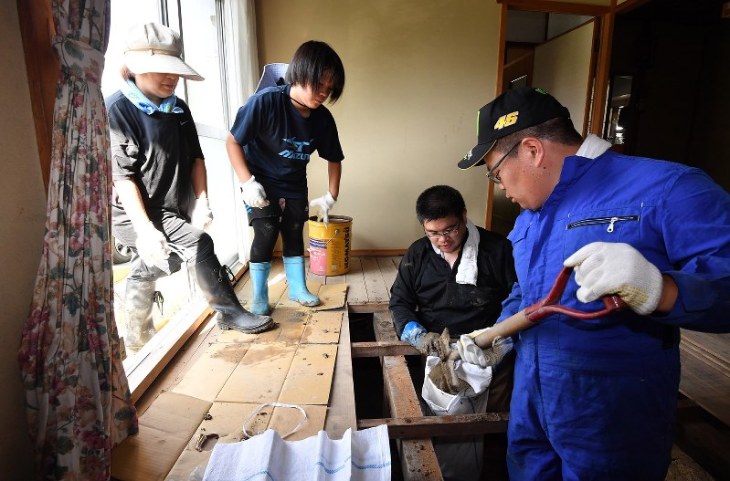 西日本豪雨で被災した民家から土砂をかき出す作業をする塔岡直樹さん(左から3人目)一家。左端は妻の薫さん、左から2人目は長女の恵さん、右端は長男の拓海さん=広島市安佐北区で2018年7月27日午後3時39分、西本勝撮影