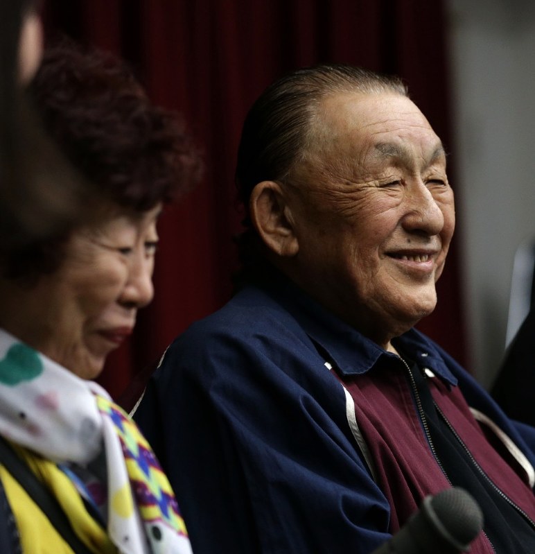 提訴後の記者会見する小島喜久夫さん(右)と夫を励ます妻麗子さん=札幌市中央区で5月17日、貝塚太一撮影
