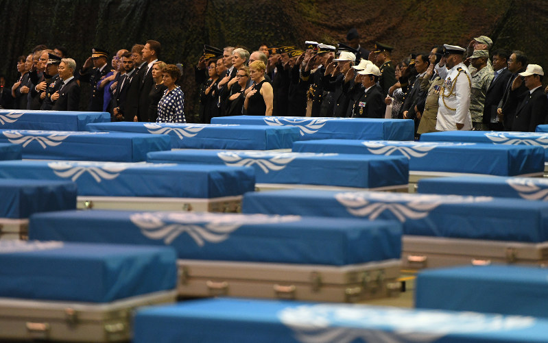 米兵の遺骨送還式典で、ひつぎの傍らで敬礼する参列者ら=ソウル南方の米空軍烏山基地で2018年8月1日、ロイター