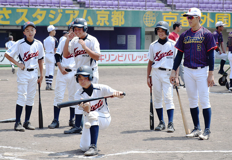 日本新薬の選手に助言を受け、バント練習をする中学生選手=京都市右京区のわかさスタジアム京都で、南陽子撮影