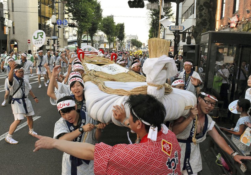 「わっしょい」のかけ声で大わらじを担いで練り歩く担ぎ手たち=福島市で2018年8月3日、柿沼秀行撮影