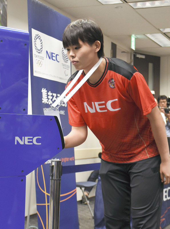 IDカードを用いて顔認証システムの実演を行うバレーボール日本代表の島村春世選手=東京都千代田区内で2018年8月7日、小林悠太撮影